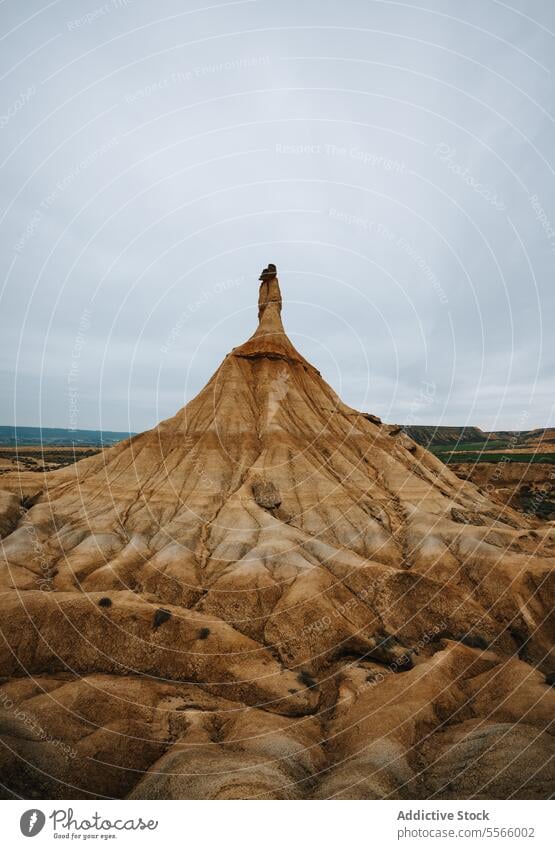 A large rock formation in the middle of a desert bardenas reales navarra arid dry sand dunes landscape geology erosion stone nature wilderness barren isolated