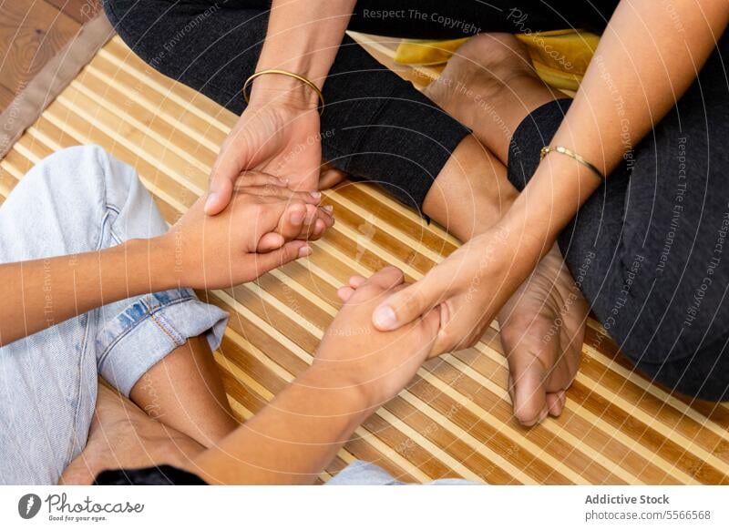 A couple of anonymous women shaking hands psychological therapy emotional support conversation sitting together talk counseling mental health wellness