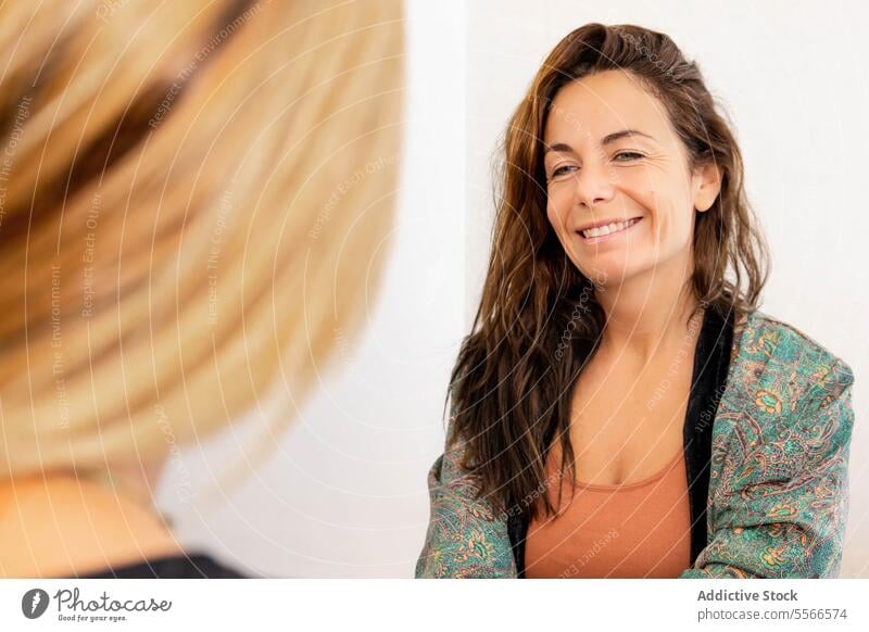 Woman doing psychological therapy with a client woman contemplating life emotional introspective challenges chair hand mouth thoughtful pondering solitude