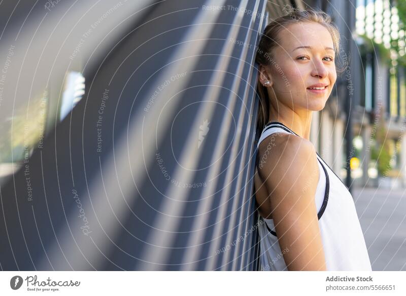 A woman in a white tank top is posing for a picture run active sport fitness exercise athlete athletic workout active lifestyle outdoor urban city jogging