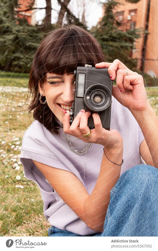 Smiling woman photographing on retro camera in city park take photo photo camera vintage tourist smile cheerful photography happy nature positive photographer