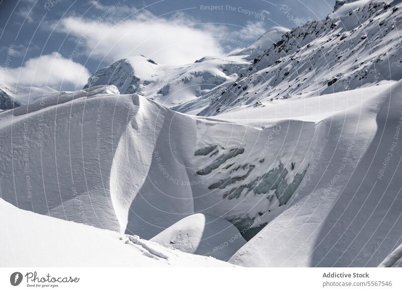 Mountain and landscape covered with snow against sky picturesque view mountain range rock covering cloudy swiss alps peak top winter natural high alpine