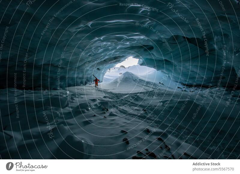 Skier with ski poles exploring cave on snow mountain unrecognizable skier walking snowy vacation exploration person hiking winter tranquil explorer adventure