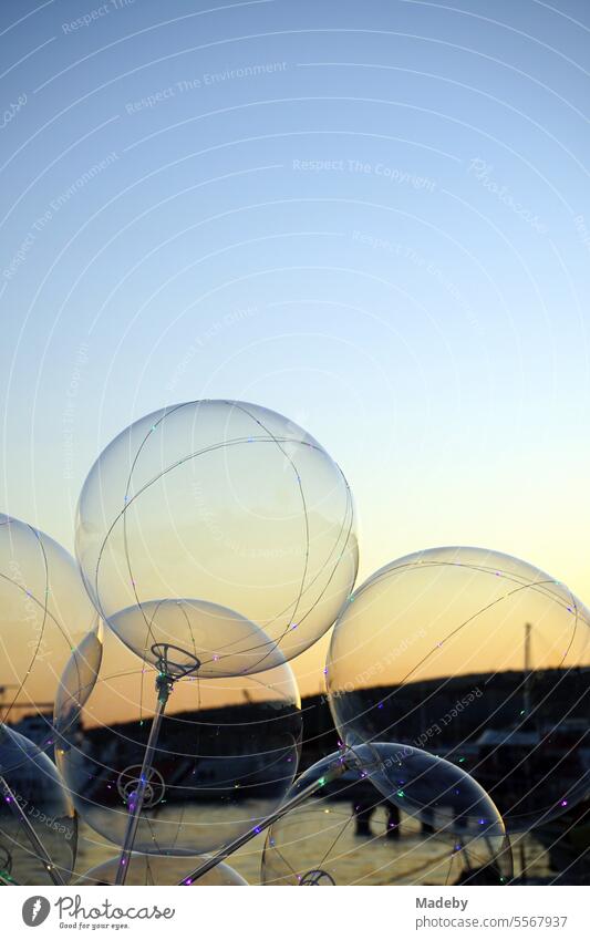 LED balloons in the light of the setting sun at the port of Cunda near Ayvalik on the Aegean Sea in the province of Balikesir in Turkey Kitsch Idyll Romance