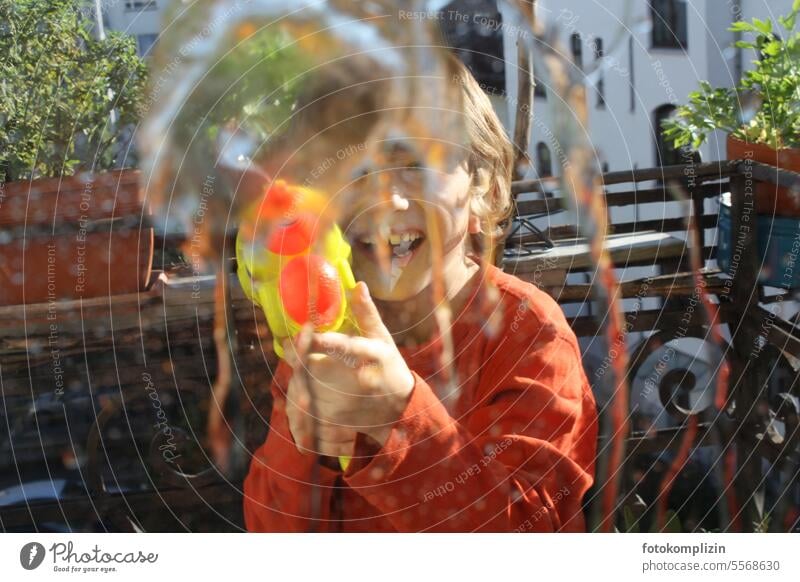 Child with water gun Boy (child) Water Brash cheerful Inject Laughter Drops of water Water pistol Splash of water Wet Fresh Refreshment Effervescent Fluid