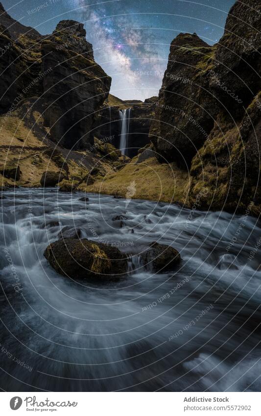 Turbulent waterfall in rocky gorge at night in Iceland turbulent flow boulder sky nature scenery landscape motion powerful force outdoors cascade dramatic