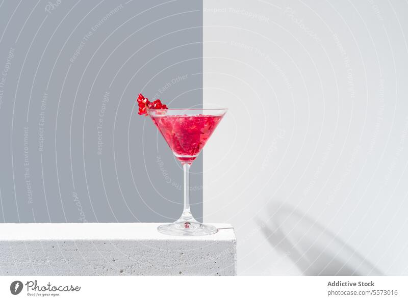 Elegant pomegranate cocktail presentation glass red garnish backdrop shadow gray vibrant beverage drink elegant decorative topping silhouette minimalistic