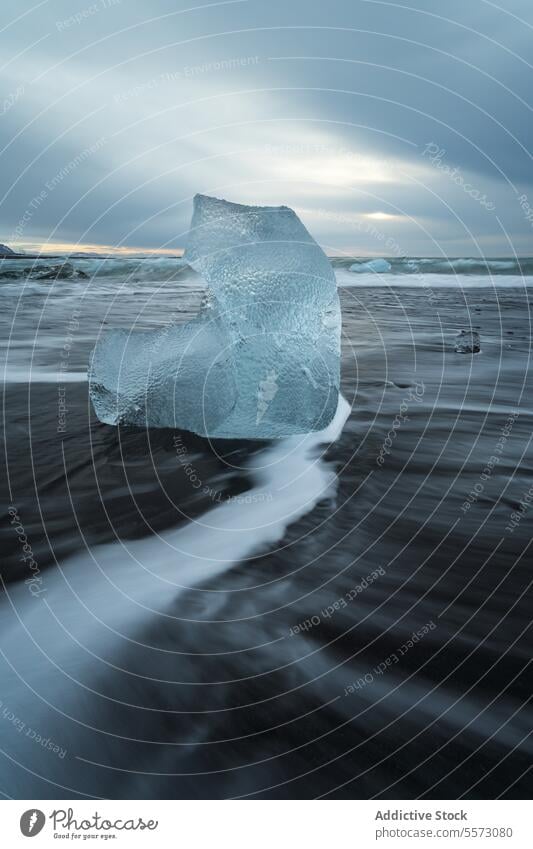 Broken ice on black beach in sea water in Iceland iceland diamond beach black sand highland landscape coast wave ocean ripple cloudy sky winter glacier