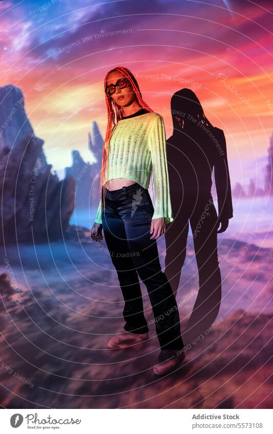 Serious woman with orange braids against mountain beautiful confident serious sunglasses afro braids radiant neon projector virtual portrait attitude glow light