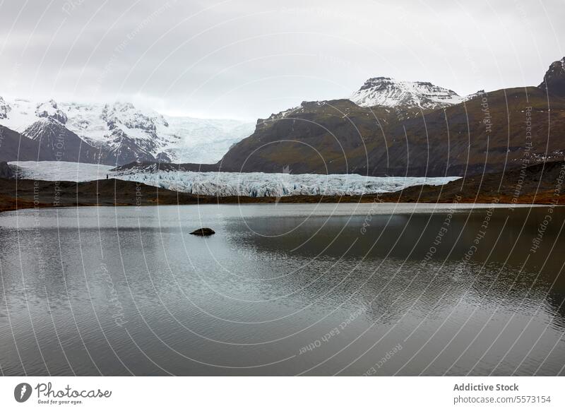 Unrecognizable person admiring glacier landscapes in in Iceland mountain water snow ice terrain view scenic peak outdoors cold nature wilderness travel