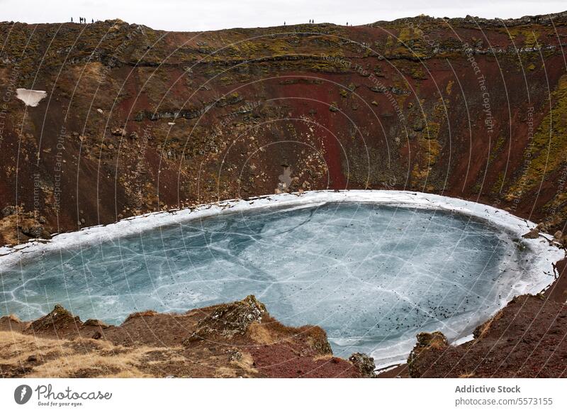 Beautiful crater with freezing lake amidst brown hilltops beautiful volcanic nature snow mountain scenic white winter cold ice calm tranquil weather season