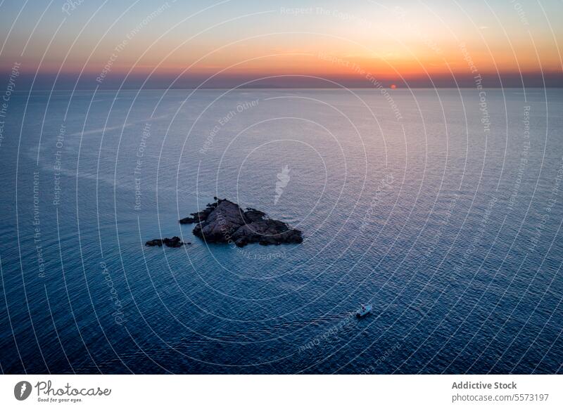 Rocky cliff islet located in blue ocean in Italy rocky ripple horizon cloudless sky sunset island nature isola rossa sardinia italy europe Castelsardo evening