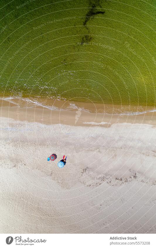 Drone shot of anonymous people at Sardinian beach Italy umbrella towel sand shore aerial li junchi summer vacation holiday sunbathing relaxation coast ocean sea