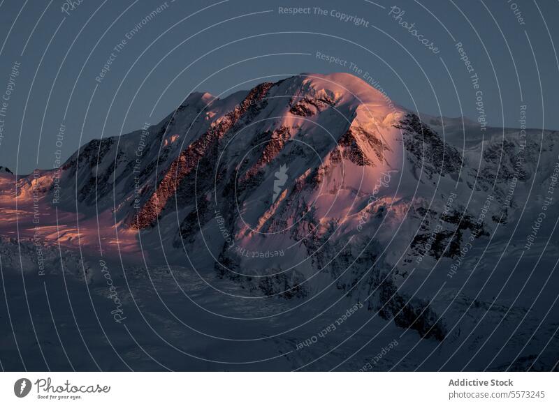 Snowy mountains under sunset sky snow ridge rocky picturesque landscape nature highland range blue sky formation scenery peak rough environment cloudless winter