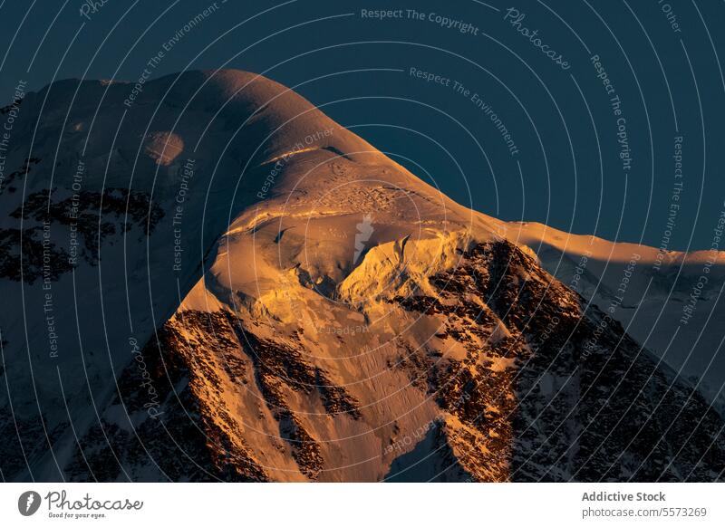 Snowy mountains under sunset sky snow ridge rocky picturesque landscape nature highland range blue sky formation scenery peak rough environment cloudless winter