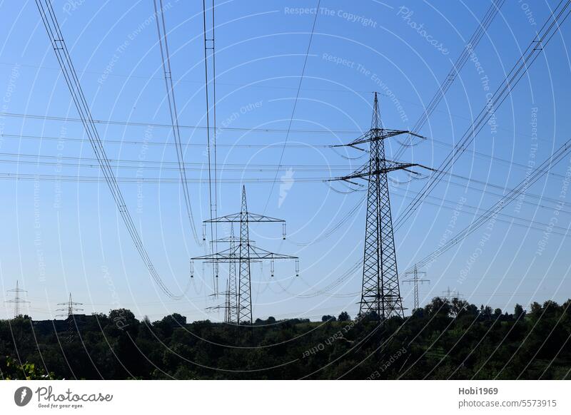 Power pole and power cable in front of a blue sky Electricity pylon Energy Force Sky Tension Transmission lines Cable Wire Pole technique Steel Metal Volt