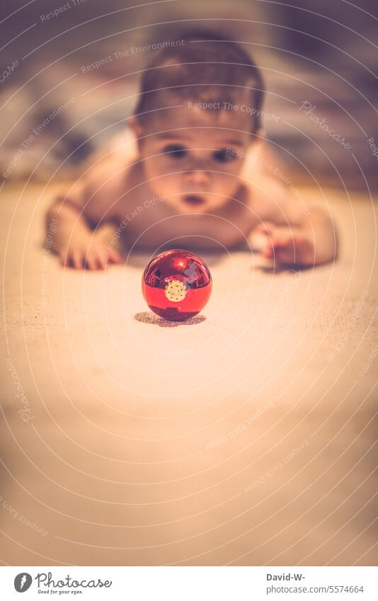 Child fascinated by a Christmas tree bauble Christmas & Advent Cute Baby Observe Discover Glitter Ball spellbound Mirror image cute Reflection Christmassy