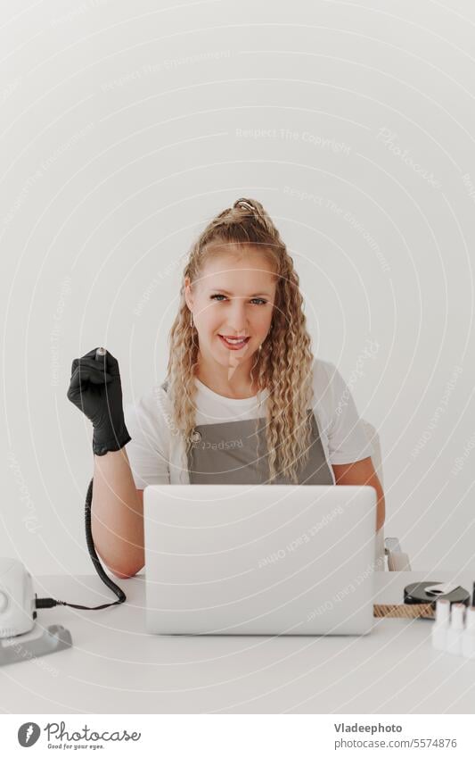 Woman Professional Manicurist at her Desk Works with a Laptop. Sign up for manicure Services, Freelancer Work Schedule salon nail manicurist laptop entry