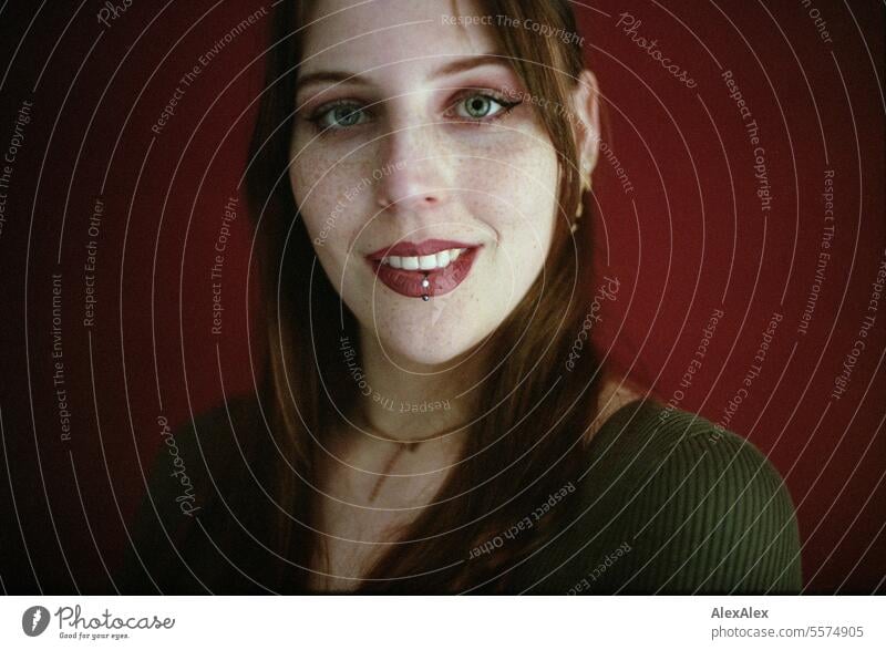 Portrait of a young woman with freckles in a green dress in front of a red wall - analog 35mm Woman Young woman Large tall woman Slim Bright Joy Athletic pretty