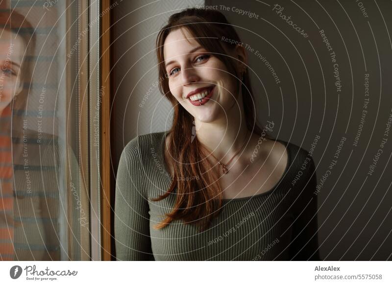 Portrait of a young woman with freckles in a green dress at a balcony window Woman Young woman Large tall woman Slim Bright Joy Athletic pretty Esthetic