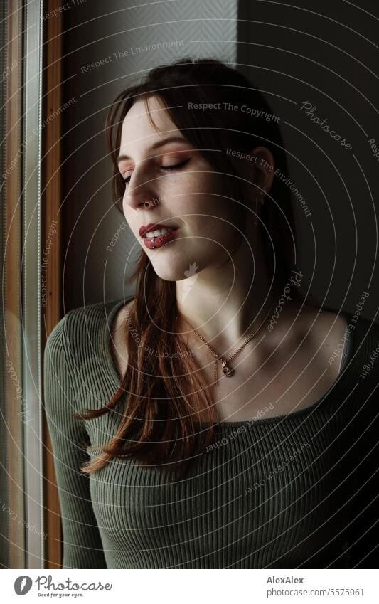 Portrait of a young woman with freckles in a green dress at a balcony window Woman Young woman Large tall woman Slim Bright Joy Athletic pretty Esthetic