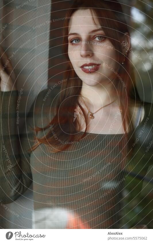 Portrait of a young woman in a green dress behind a window pane Woman Young woman Large tall woman Slim Bright Joy Athletic pretty Esthetic Appealing Attractive