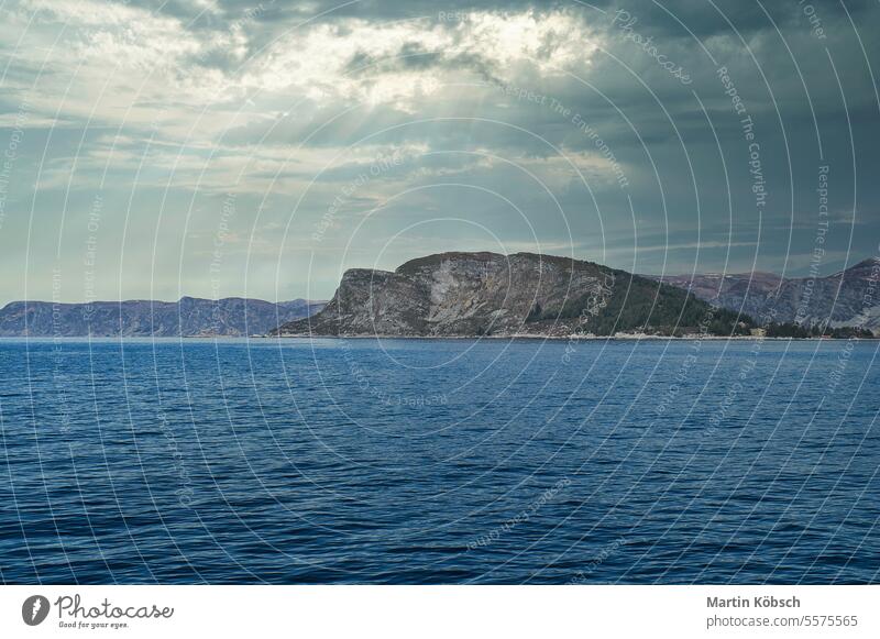 Fjord with mountains on horizon. Water glistens in the sun in Norway. Landscape norway snow scandinavia tourism sky coast calm ocean landscape nature horizontal