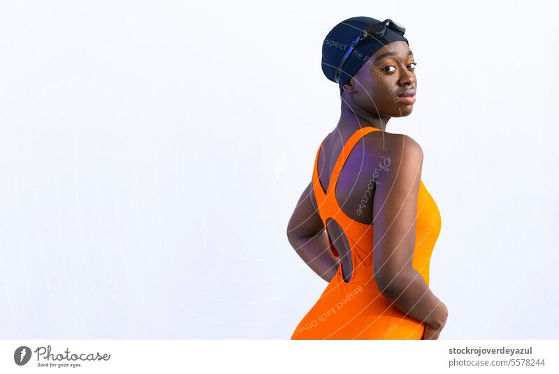 Black young woman in swimsuit looking at camera, posing with plain white background female black swimming pool heated orange healthy smiling blue lifestyle