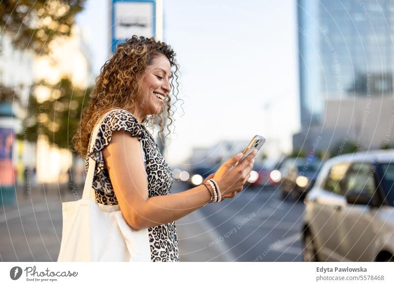 Young Woman Booking Taxi On Mobile App On The City Street young adult street outside confidence smiling enjoy laughing fun natural one person portrait woman