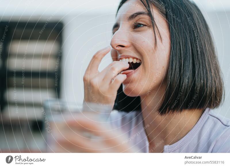 Woman smiling while holding many pills in her open hand, she is about to eat them, supplementing woman happy painkiller vitamin healthy sick prescription tablet