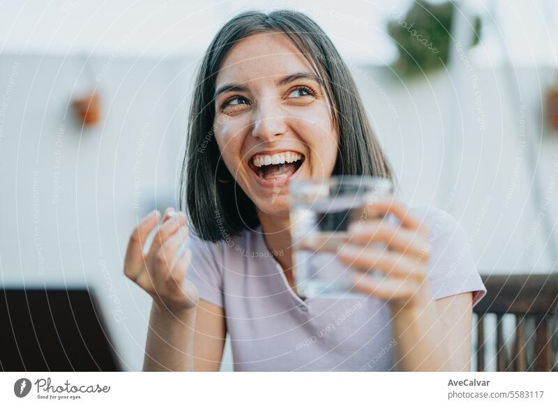 Woman sitting at home and taking painkillers pills while working on laptop, freelancer concept. supplement woman happy vitamin healthy pure wellness lady smile