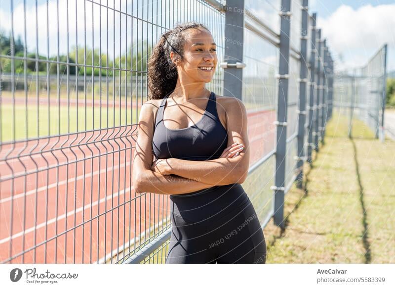 Athletics coach posing leaning on a fence waiting for her students to start practice. Sports work. person women fitness female lifestyle exercise healthy young