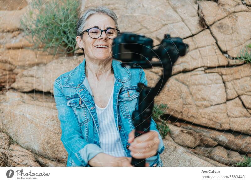 Senior joyful woman recording a video for her family explaining her vacation. Old photographer. senior retirement streamer live female lifestyle women person