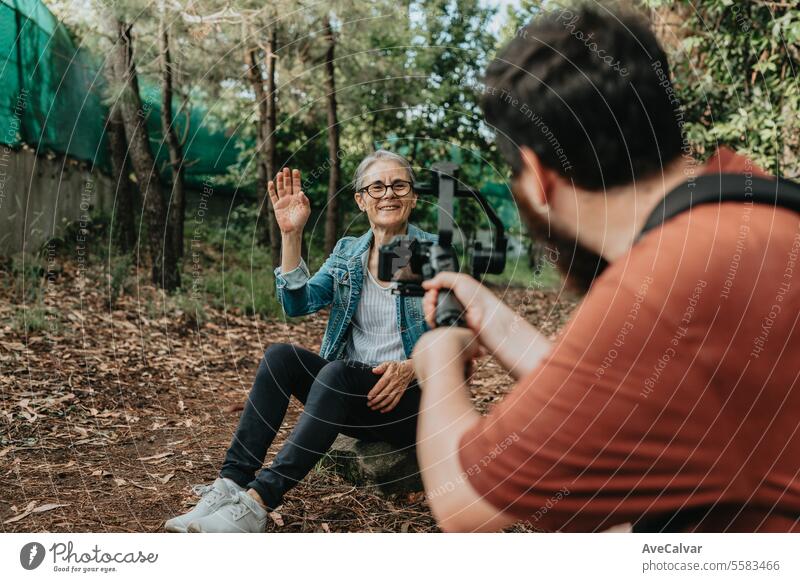 Old woman with a new hobby with her son, advertising and telling anecdotes to upload to networks. senior streamer live video retirement person outdoors together