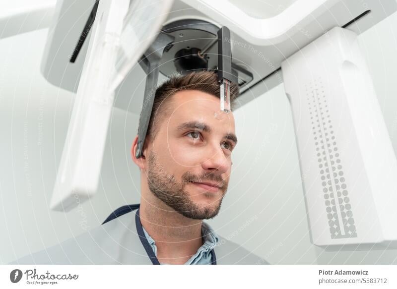 Patient standing in x-ray machine at dental clinic xray radiology doctor patient digital scan technology radiography scanner panorama dentist examination