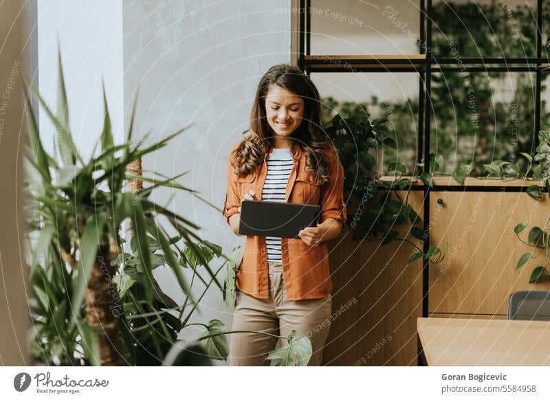 Young woman standing with digital tablet at the office american business business people businesswoman career caucasian alone communication corporate coworkers