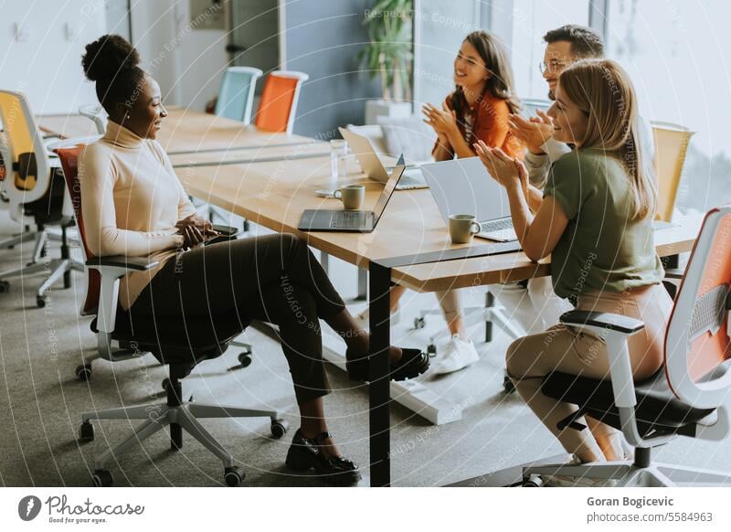 Young multiethnic startup team working in the modern office black african american young happy laptop computer casual company female meeting together