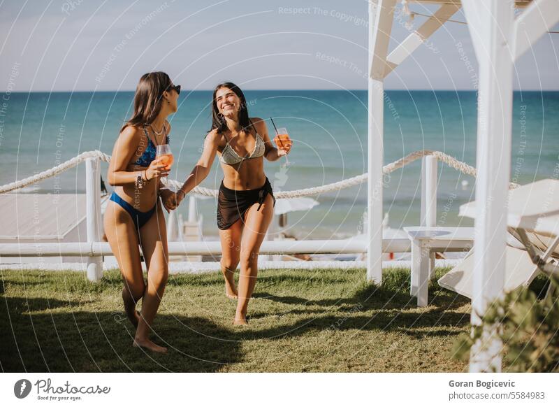 Smiling young women in bikini enjoying vacation on the beach adult clothing day drink drinking emotion fashion female happiness holiday italy leisure activity