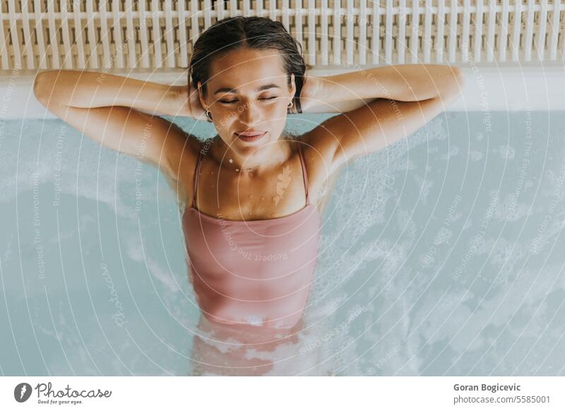 Young woman relaxing in the indoor bubble pool adult alone attractive beautiful beauty bikini body caucasian day enjoy enjoying female fresh happy hold