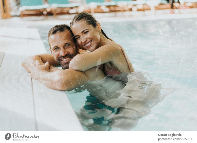 Young couple relaxing in the indoor swimming pool adult attractive beautiful beauty bikini body caucasian day enjoy enjoying female happy hold lifestyle love