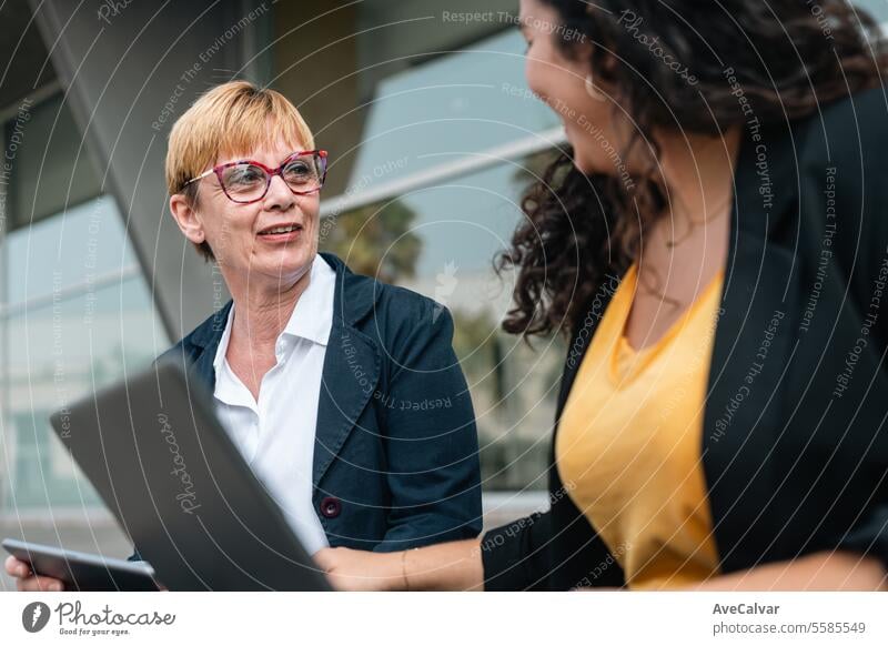 Friends businesswoman working using laptops together outside the office. Working process project outdoors person women meeting teamwork professional adult