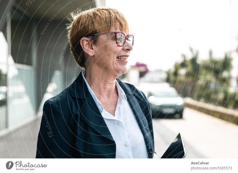 Senior businesswoman in front of a company building happy smiling to camera, woman at business office colleague person female portrait lifestyle adult senior