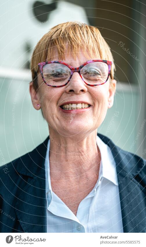 Senior businesswoman in front of a company building happy smiling to camera, woman at business office colleague person portrait women mature senior female old