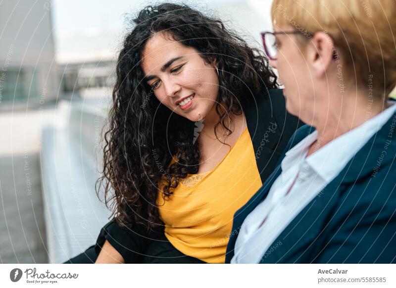 Two co workers chill during their free spare time in a park sharing ideas and stories. Showing phone outdoors person woman young adult happy female business