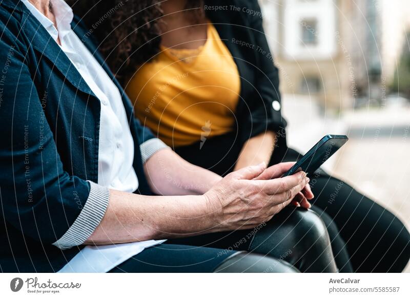 Two co workers chill during their free spare time in a park sharing ideas and stories. Showing phone businesswoman office outdoors colleague person technology