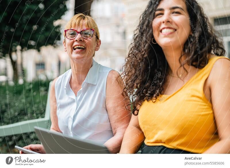 video call with relatives while using laptop with her daughter sitting in a bench at the street businesswoman office outdoors colleague person female happy