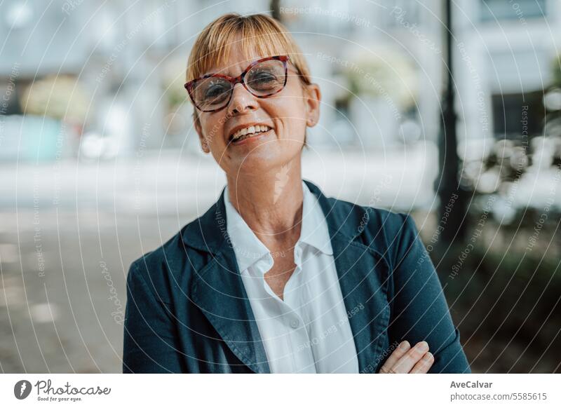 Portrait of confident mature businesswoman standing arms crossed on street, happy senior woman job colleague person portrait adult caucasian age lifestyle