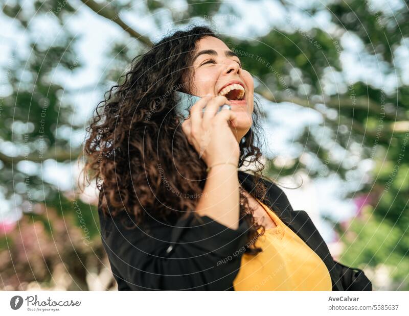 Junior Hispanic Woman using smartphone outdoors to close deals.Woman in business during office hours businesswoman colleague mobile female person happy young