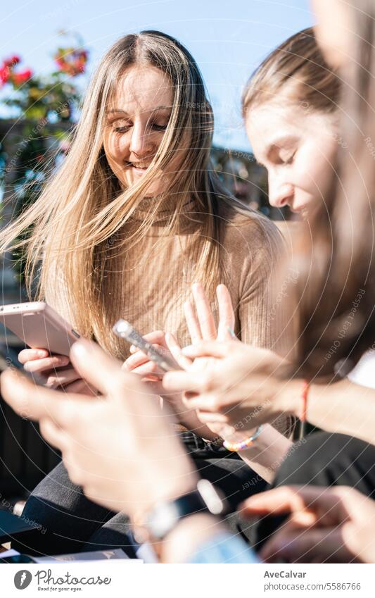 College girls taking a break from studying showing messages on phones while talking and laughing. group students happy bonding reading friends friendship smart