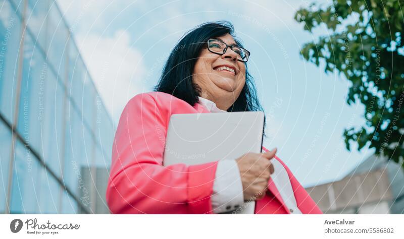 Businesswoman taking a break after a hard day at work,proud of the tasks completed holding a laptop. person adult women female happy business businesswoman